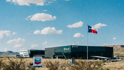 Modern Microsoft office complex with a Chevron sign in front and a flag flying against a clear blue sky